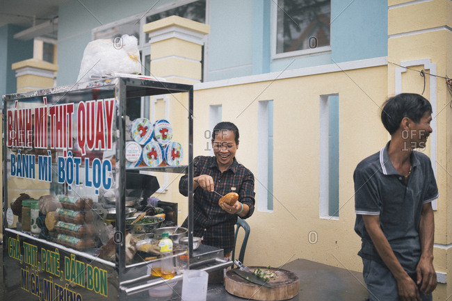 March 30, 2017: A woman makes a Banh Mi sandwich with pork and herbs street side in Danang, Vietnam.