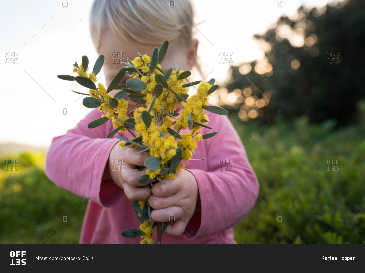 Toddler girl with bunch of yellow flowers