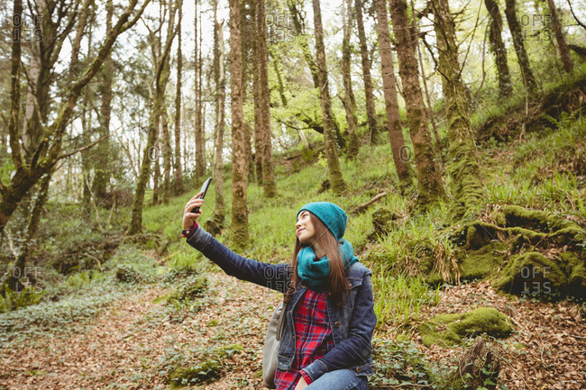 Woman taking selfie from mobile phone in forest