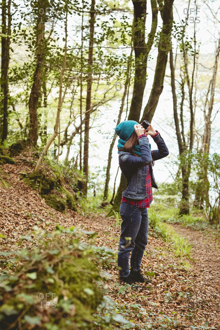 Woman clicking photos of nature in forest