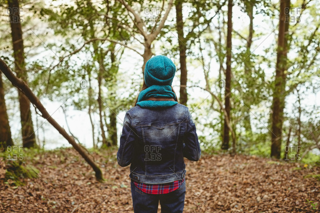 Rear view of woman standing in forest