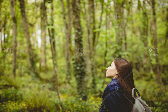 Thoughtful woman standing in forest