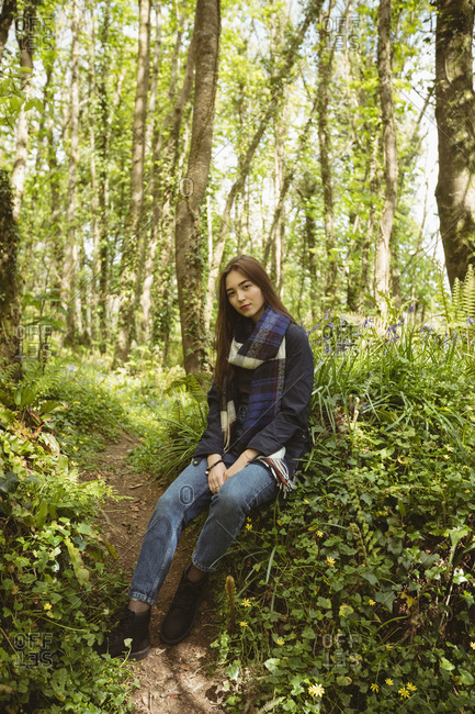 Portrait of woman sitting in forest on a sunny day