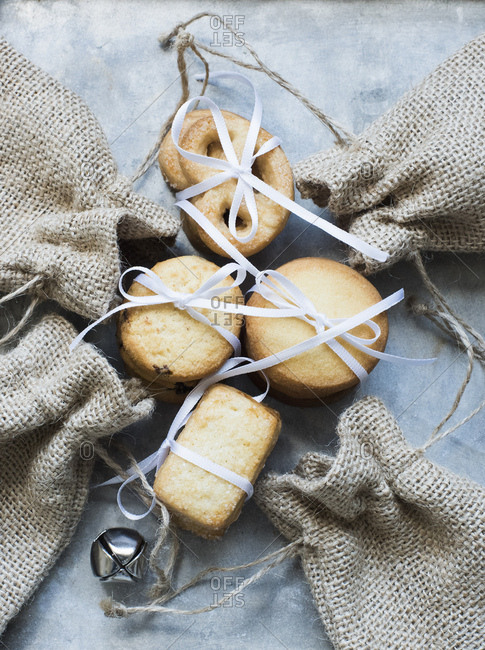 Overhead view of shortbread cookies tied with white ribbon and burlap bags