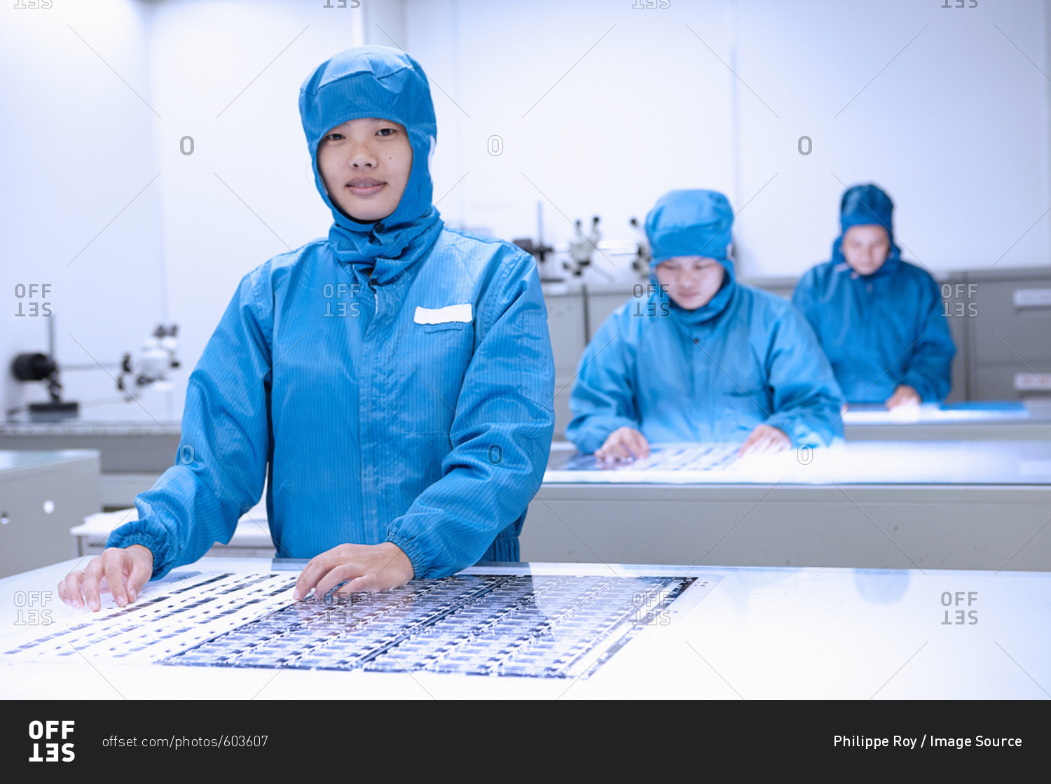 Portrait of female factory worker in flexible electronics factory clean room