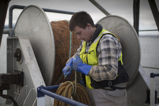 Fisherman preparing net reel - Offset