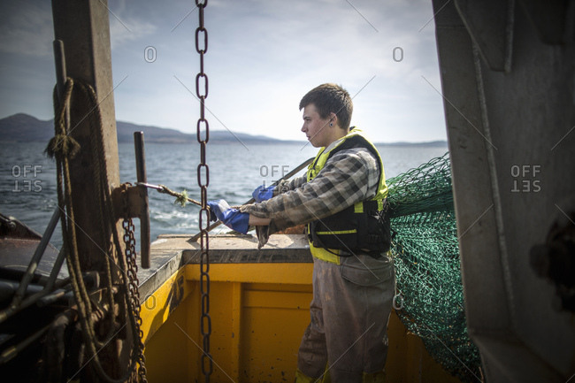 Fisherman reeling in net, Isle of Skye, Scotland