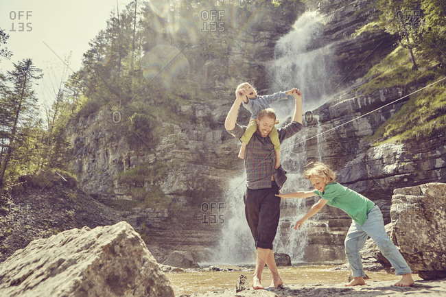 Two generation family having fun by waterfall, Ehrwald, Tyrol, Austria