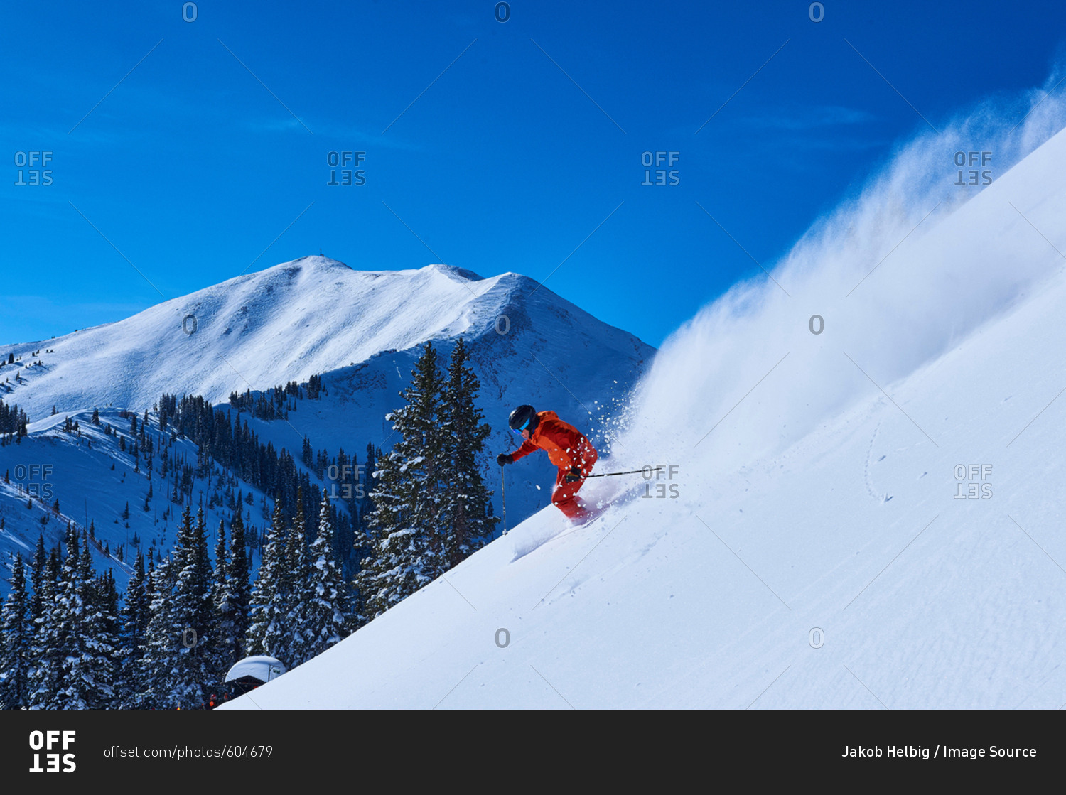 Man skiing down steep snow covered mountainside, Aspen, Colorado, USA
