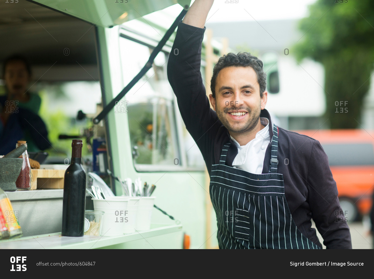 Portrait of small business owner opening van food stall hatch