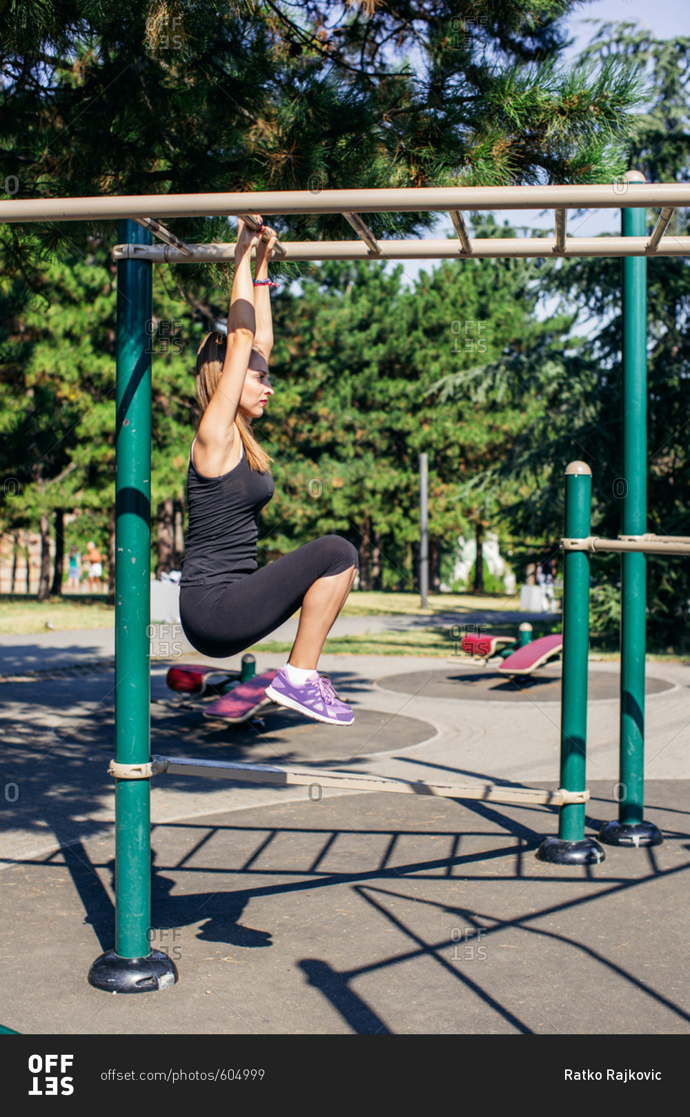 Woman using monkey bars in workout