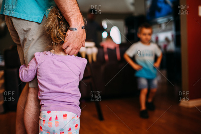 Toddler girl hugging daddy's leg