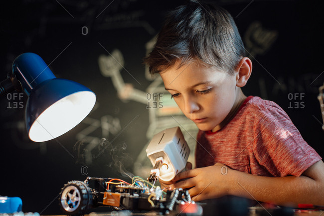 Portrait of a skilled young boy working with a soldering gun