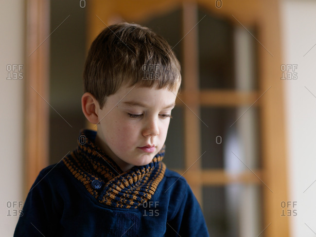 A portrait of a young boy thinking at home with a short depth of field and blurred background