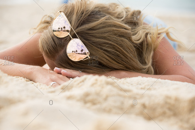 Blonde Woman With Sunglasses Sunbathing On A Sandy Beach Stock