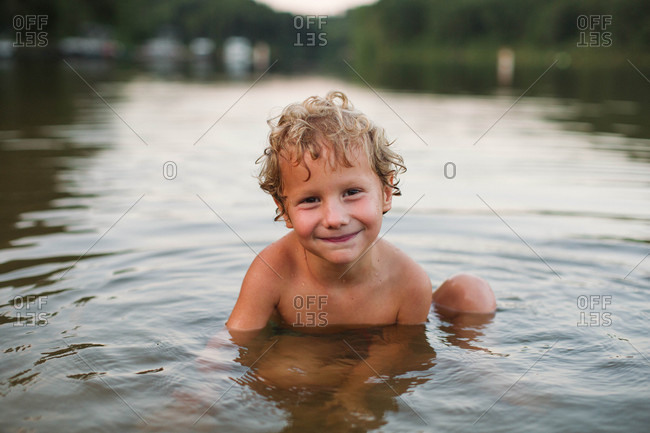 Grinning boy in river water