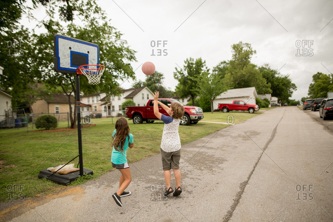 Kids shooting baskets in street