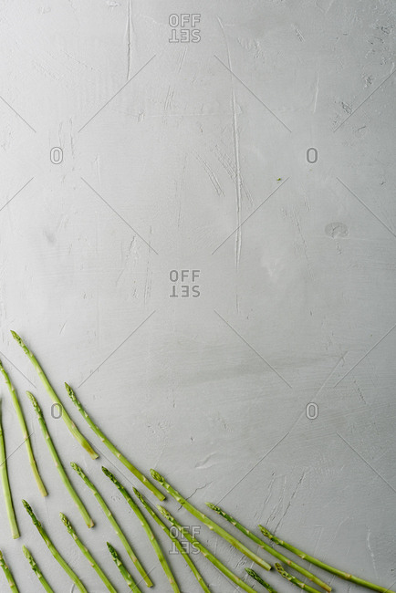 Food inspiration. Directly above view of asparagus river flowing on concrete background, copy space