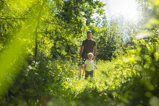 Father and son (2-3) in forest