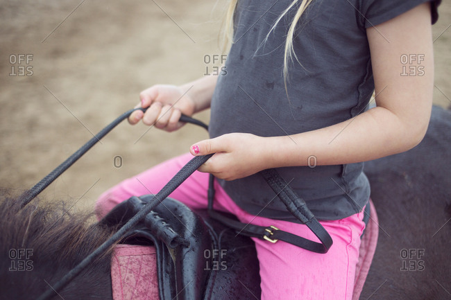 Close-up of girl (4-5) sitting on pony
