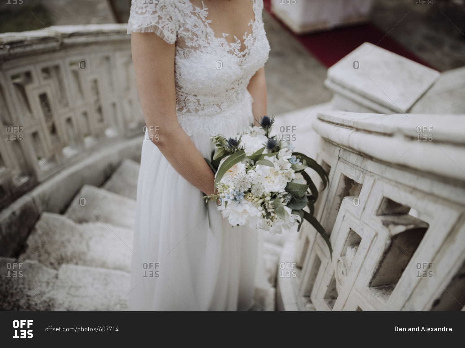 Bride standing on staircase holding wedding bouquet