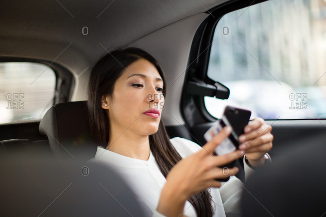 Businesswoman paying via app for taxi cab ride
