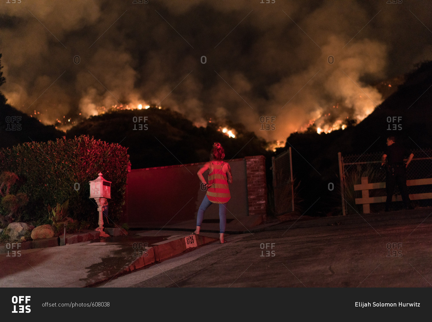 A resident in Burbank, CA watches flames advance near homes from the La