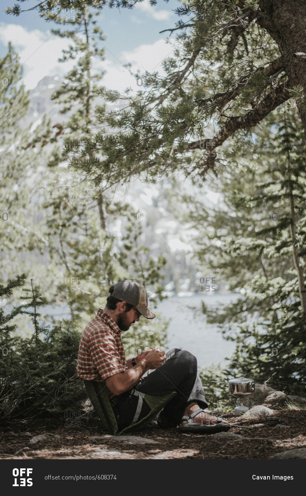 Side view of hiker sitting in camping seat at forest