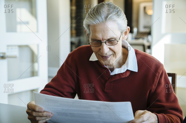 Senior man reading documents in financial advisor's office
