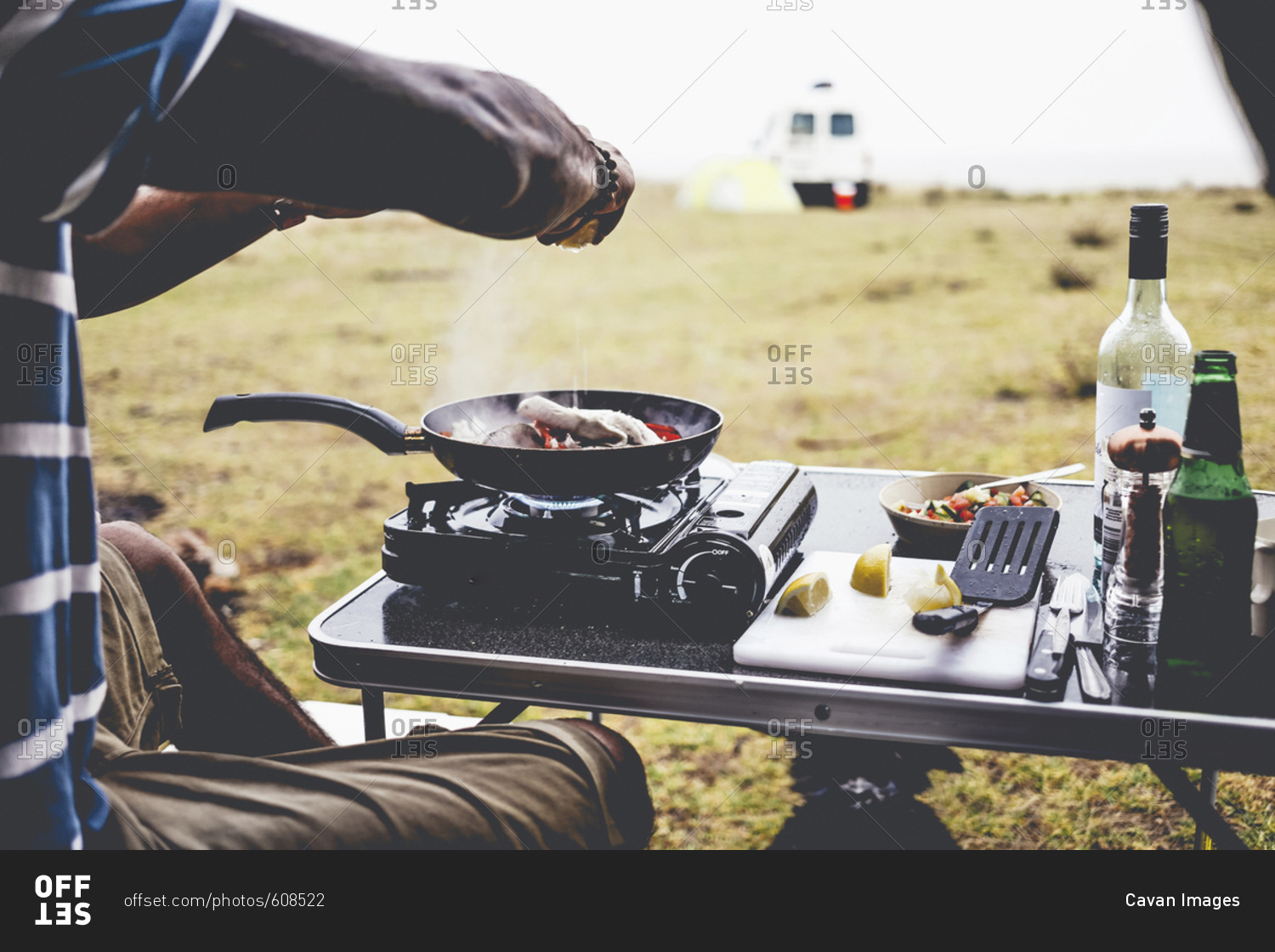 Cropped image of man preparing food on camping stove at campsite