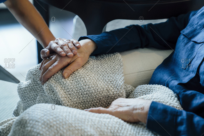 Cropped image of home caregiver consoling senior woman