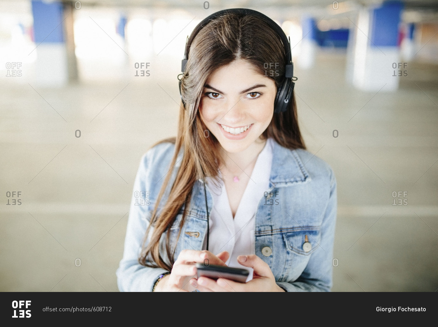 Happy brunette listening to music in parking lot