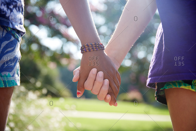 Close up of female couple holding hands