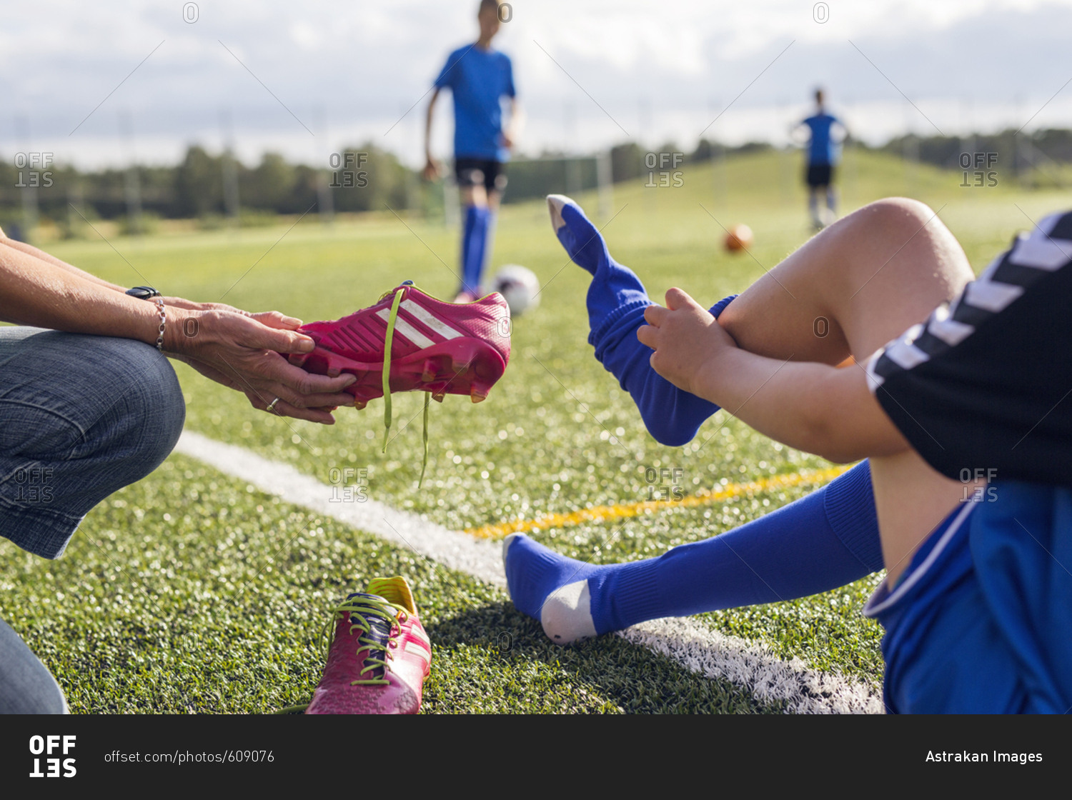 Mother helping son (1011) get dressed for soccer practice stock photo