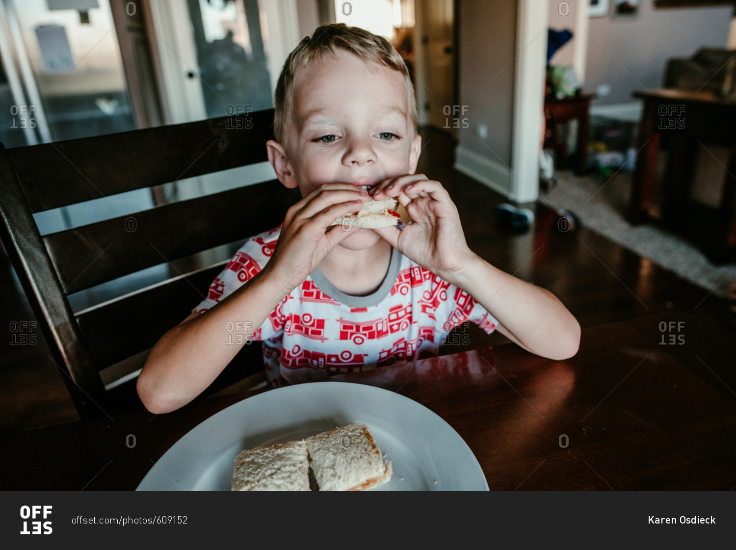 Little boy eating a peanut butter and jelly sandwich stock photo OFFSET