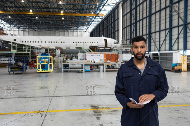 Portrait of aircraft maintenance engineer standing at airlines maintenance facility