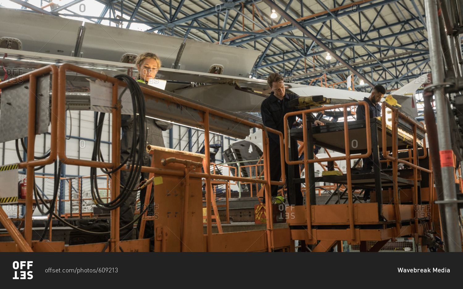 Aircraft maintenance engineers working on aircraft maintenance platform at airlines maintenance facility