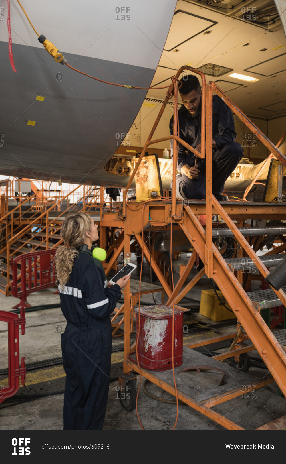 Aircraft maintenance engineers working over an aircraft at airlines maintenance facility