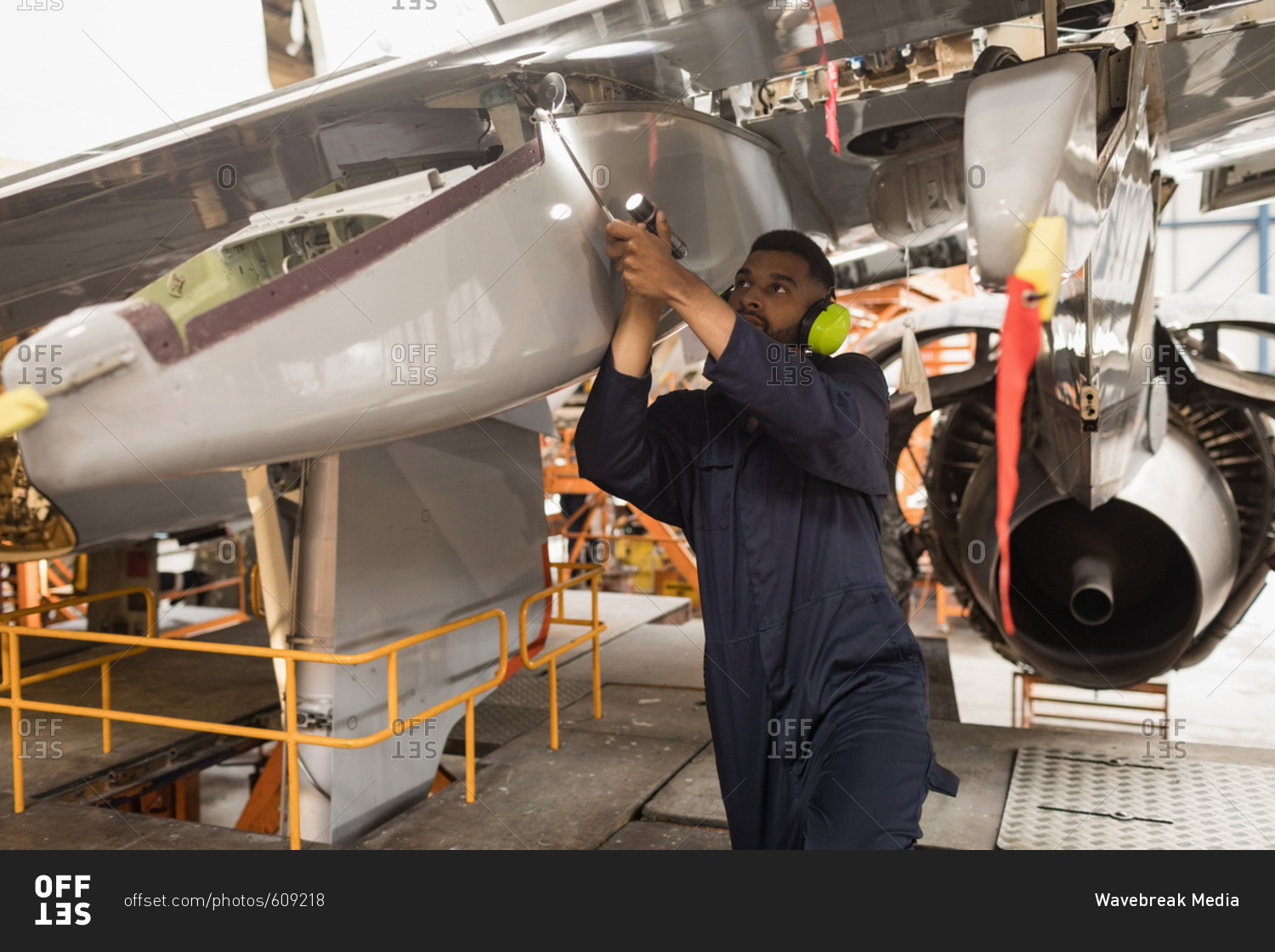 Male aircraft maintenance engineers working over an aircraft at