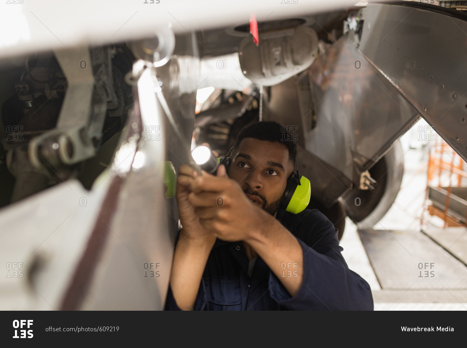 Male aircraft maintenance engineers working over an aircraft at