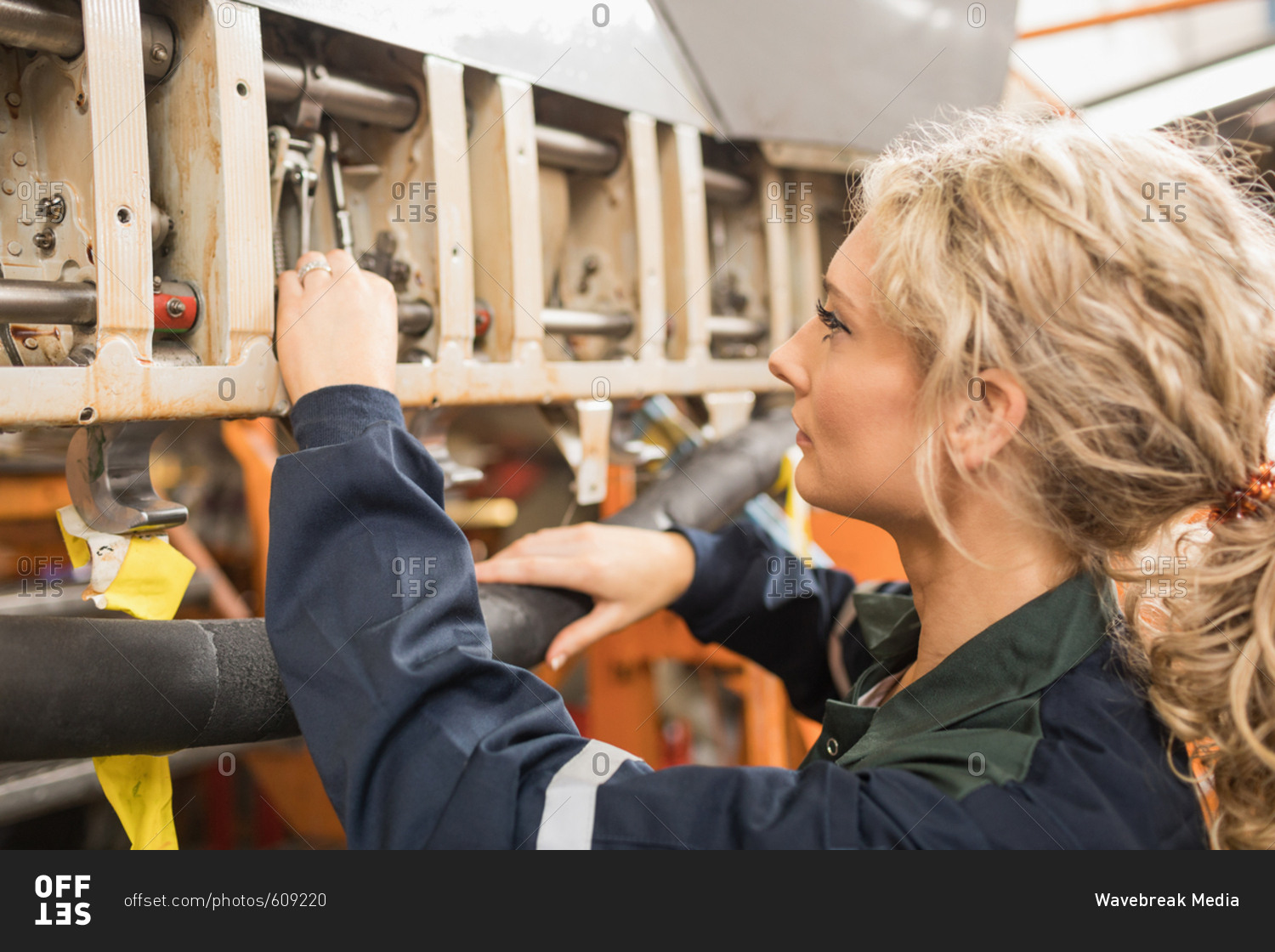 Female aircraft maintenance engineers working over an aircraft engine at airlines maintenance facility