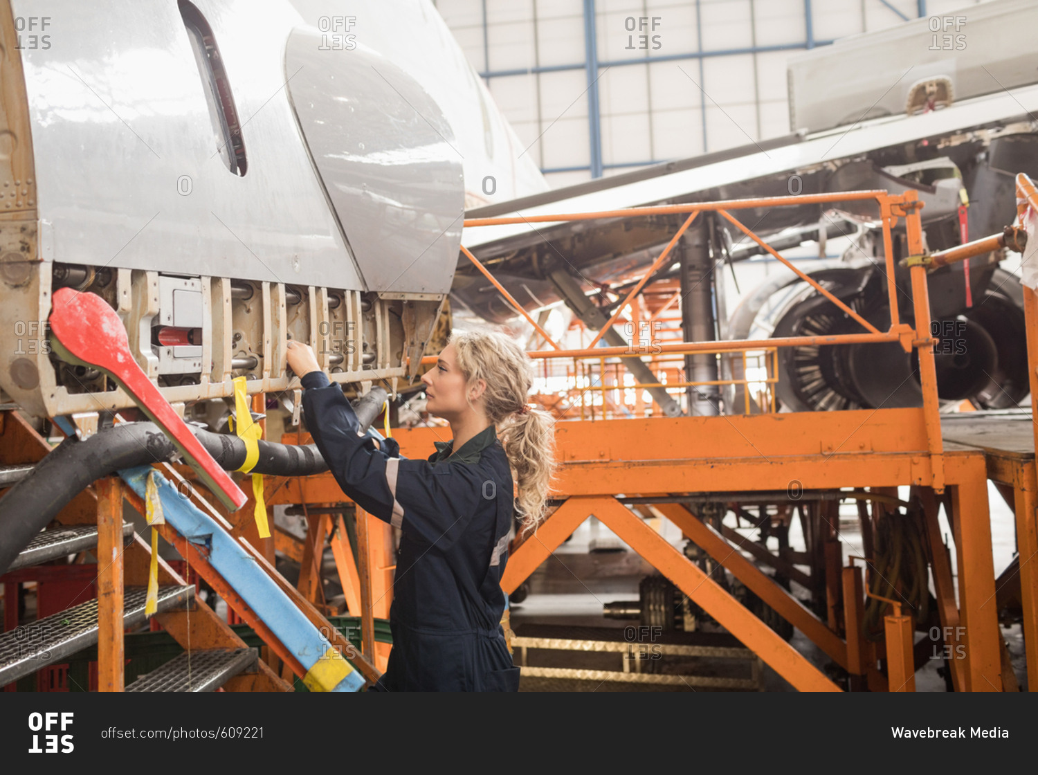 Female aircraft maintenance engineers working over an aircraft at airlines maintenance facility