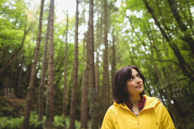 Thoughtful woman standing in forest
