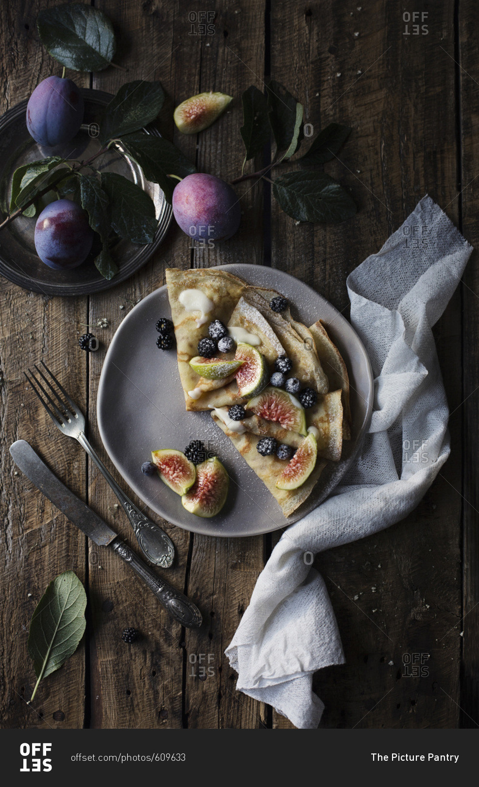 Crepes with figs and blackberries on wooden table. Top view