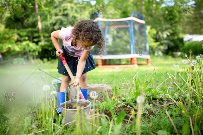 Girl digging in dirt with a shovel