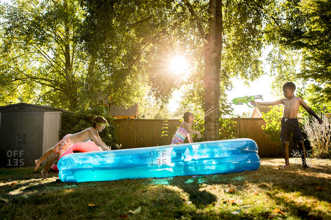 Kids playing in backyard swimming pool