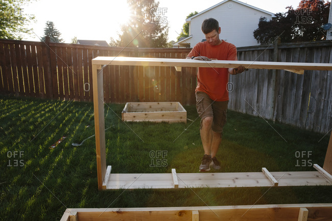Man building wood box in yard