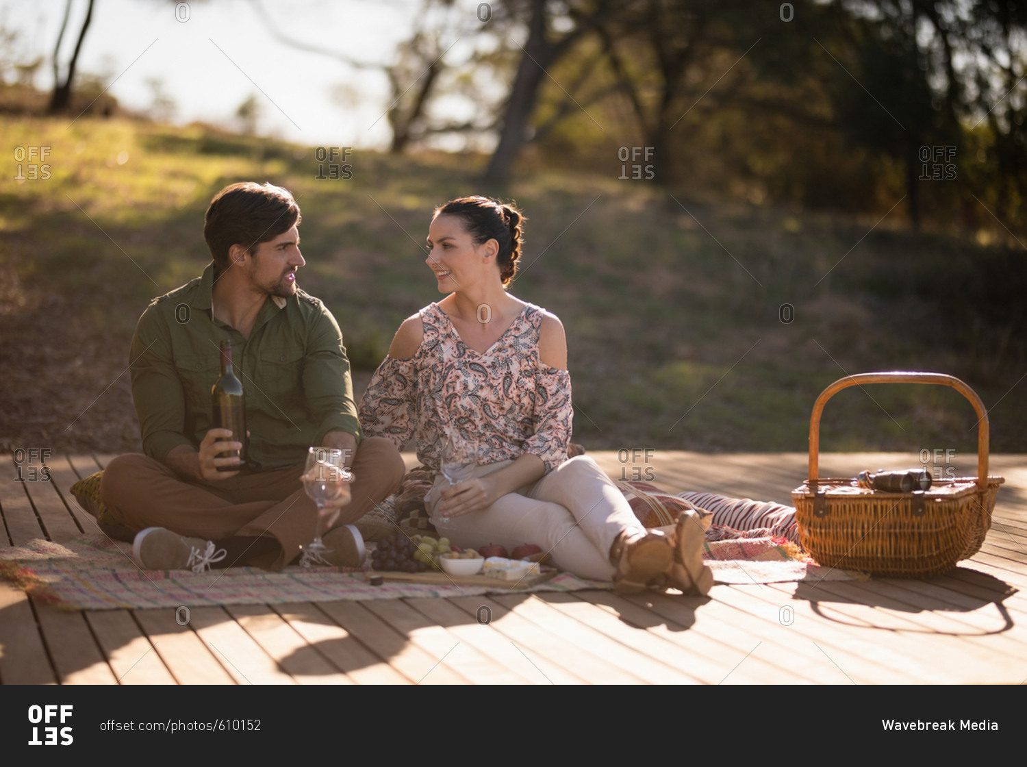 Couple having drinks together on wooden plank during safari vacation