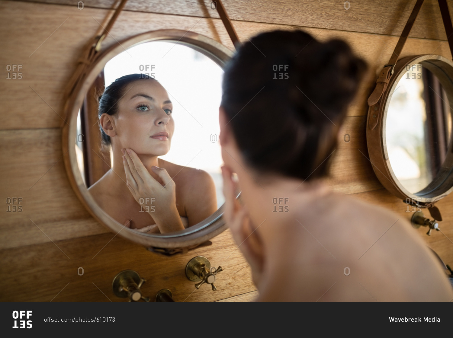 Woman looking at mirror in cottage during safari vacation
