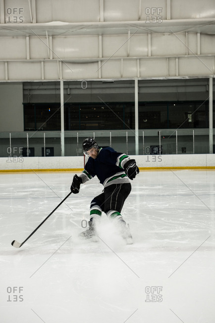Full length of male player playing ice hockey at rink